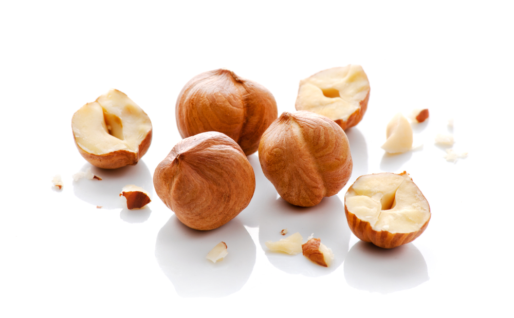 Full and halfs of hazelnuts on white background. Isolated